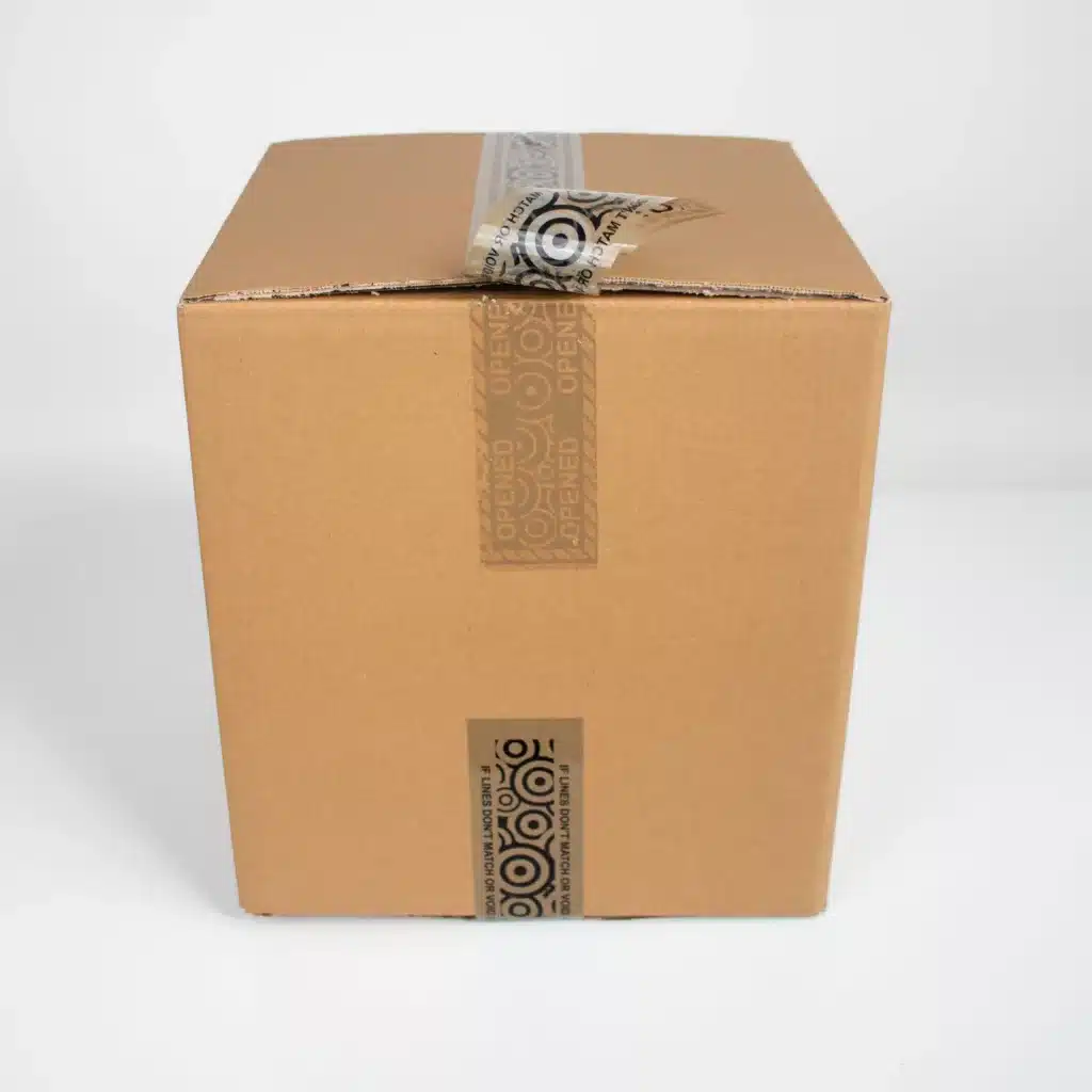 Brown tamper evident box tape with printed circles applied to a cardboard box showing the void message from Tampertech
