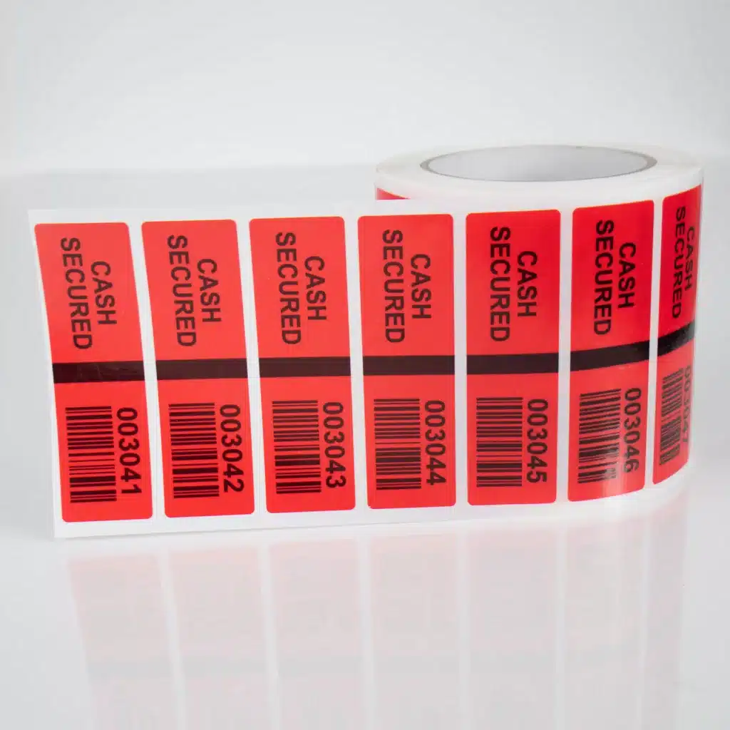 Image of Tampertech red non-residue Cash Secure label with security cuts, sequential number linked to barcode, 100mm x 30mm, 1000 labels on a roll.