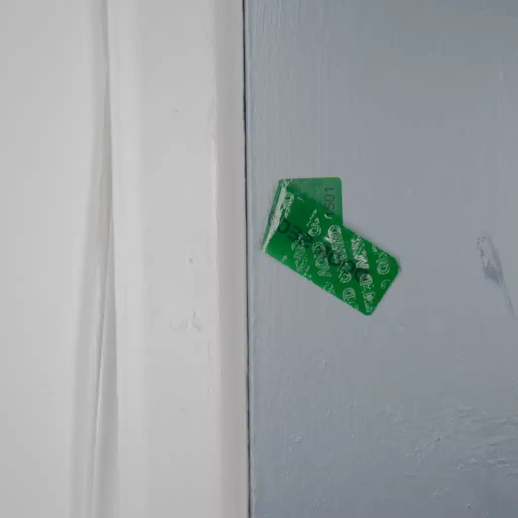 Image of a Tampertech tamper evident Door Secured label that has been removed, showing that it leaves no residue behind and has a void message in the label.