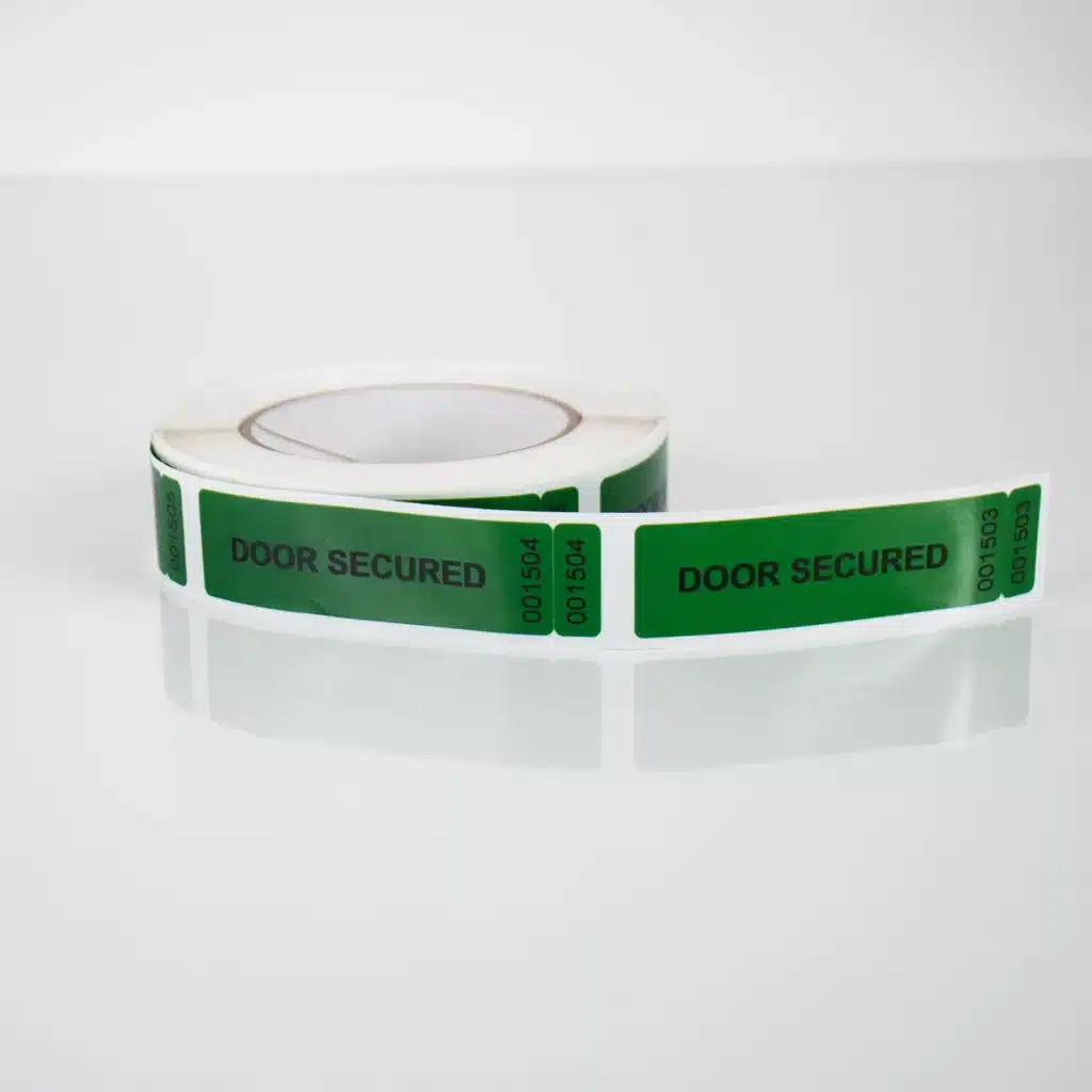 Image of a roll of green Tampertech tamper evident Door Secured non-residue label, 85mm x 25mm + 25mm x 10mm DNT, 1000 labels per roll.