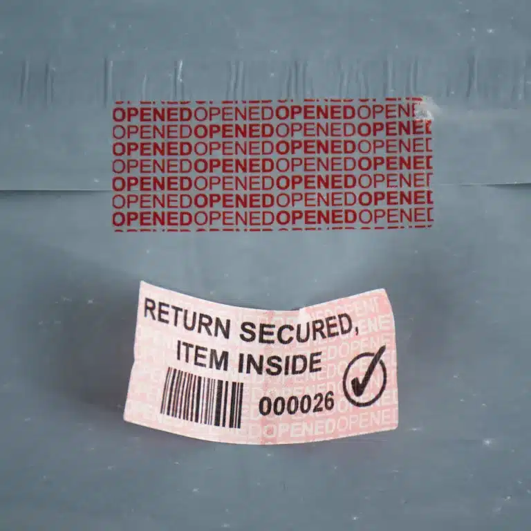 E-commerce Returns Fraud Retail Image of E-Commerce permanent red paper tamper evident label removed from a bag showing "OPENED OPENED" void message and the label after it has been removed