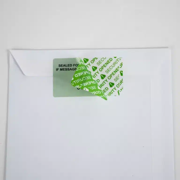 Paper Image of a Secure Item permanent green paper tamper evident label half removed from an envelope showing "SECURITY OPENED" void message
