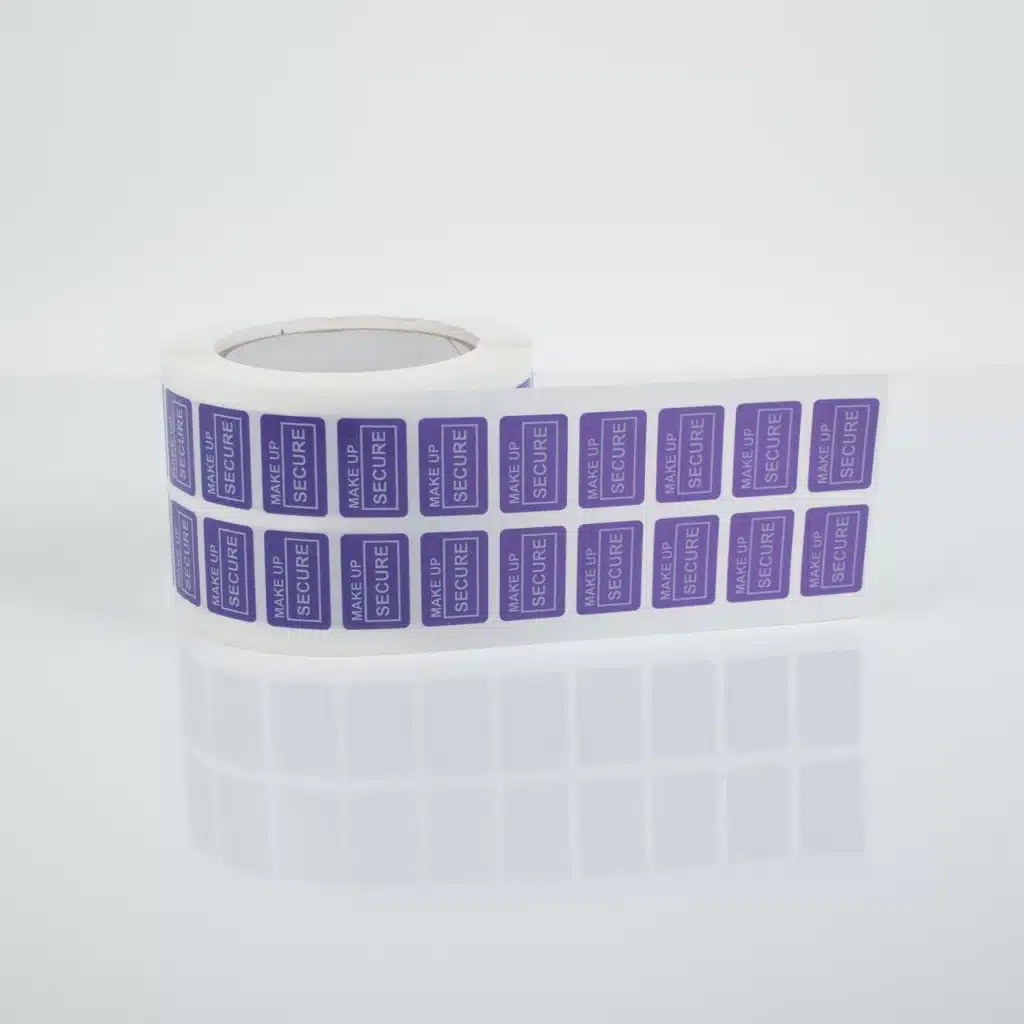 An image of a roll of small non-residue tamper evident beauty and cosmetics purple labels, 20mm x 30mm from Tampertech for retail packaging