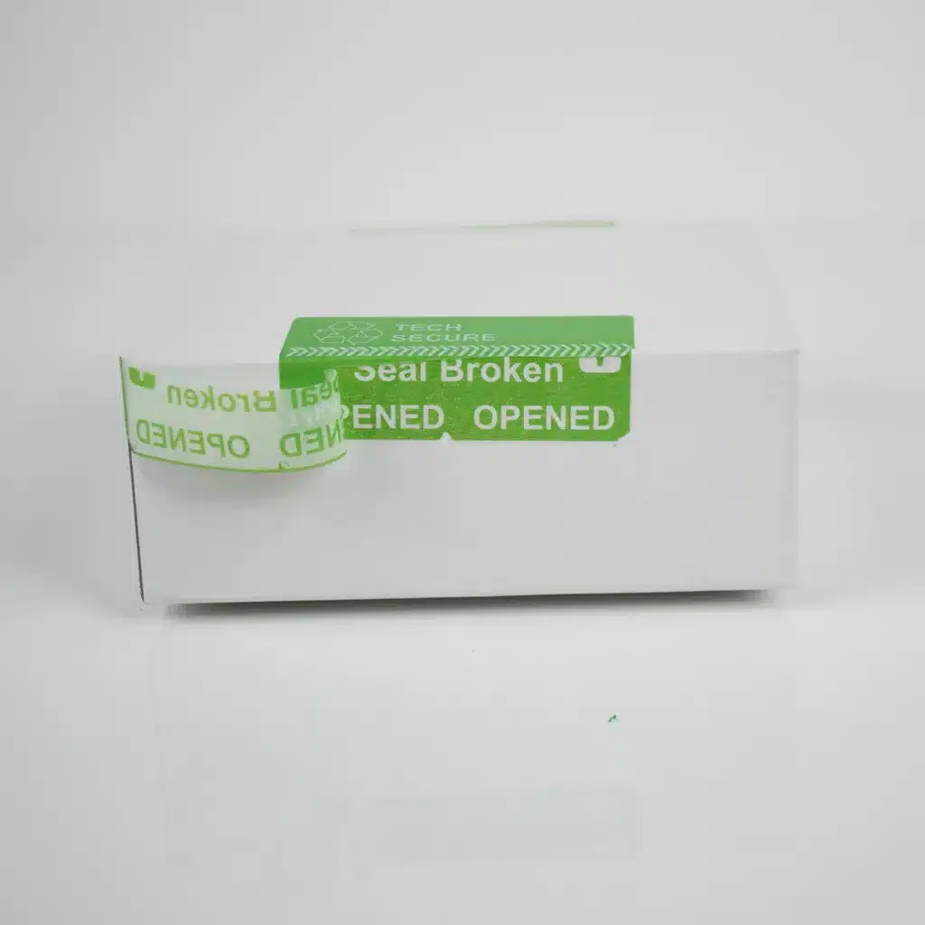 Image of green permanent Tech Secure tamper evident label from Tampertech applied to packing and partially removed demonstrating the security cuts in the label and the permanent void message
