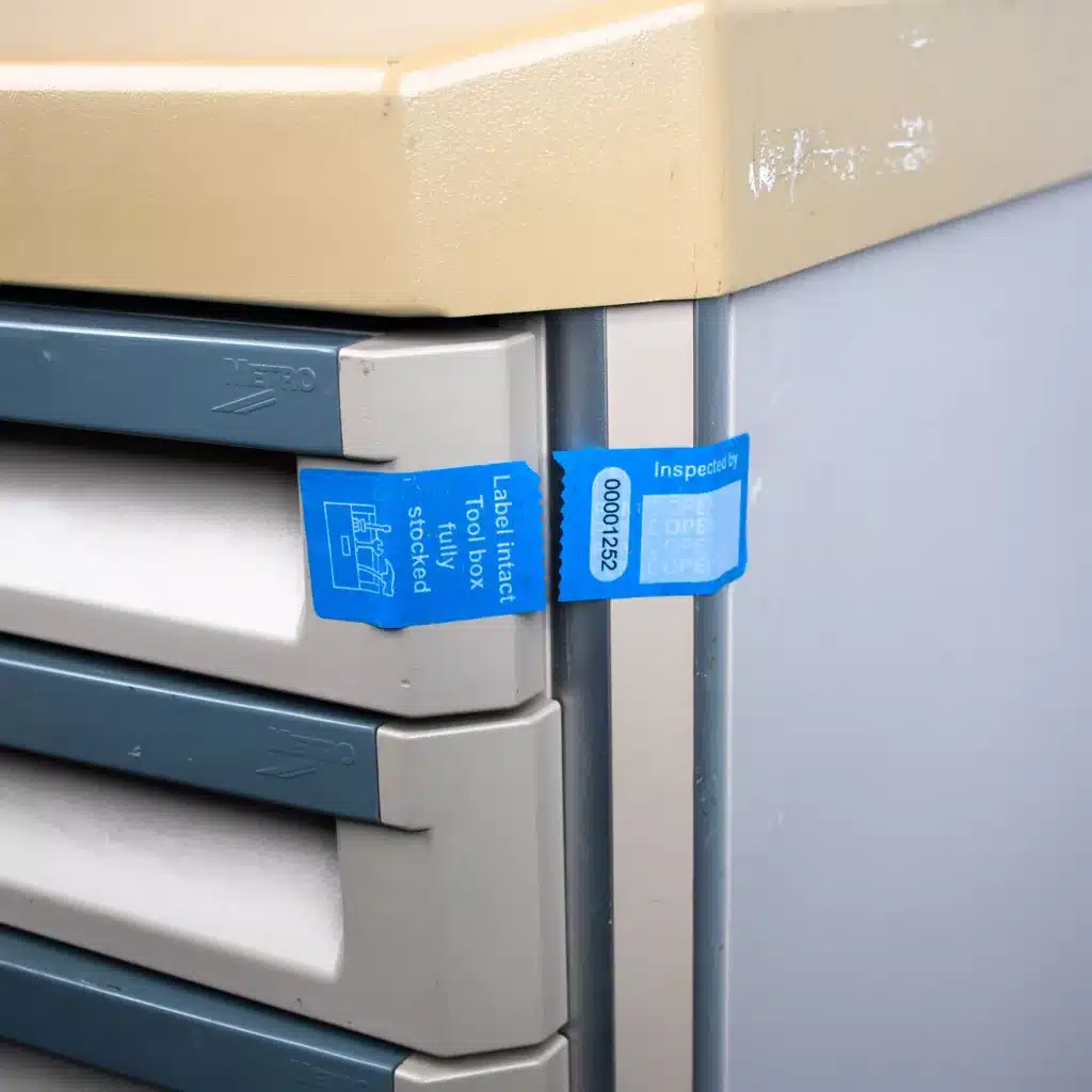 Tool box secure non-residue label removed from a tool trolley showing security cut label after draw opening.