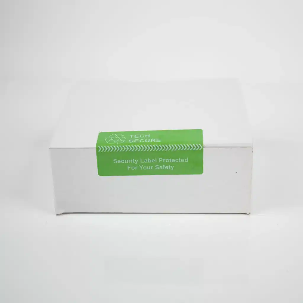 Image of green permanent tamper evident label applied to tech packaging from Tampertech