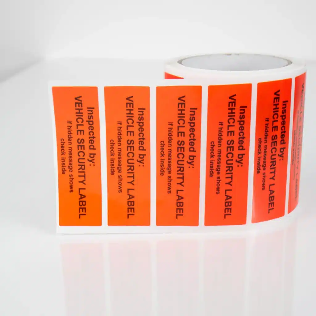 Roll of Tampertech red non-residue vehicle security labels, 100mm x 30mm with sequential numbers and signature panel, 1000 labels per roll.